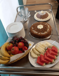 Kuchen, Obst und Nachtisch auf einem Servierwagen.