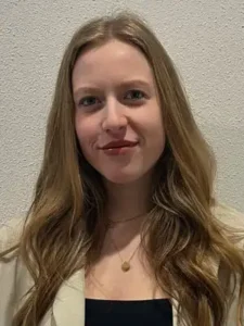Ein Portrait von einer junge Frau, die in die Kamera lächelt.