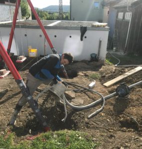 Ein Hausmeister arbeitet im Garten.