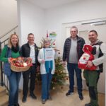 fünf Personen stehen im Eingangsbereich unseres Hauses, die Bereichsleitung hält einen Korb mit Süßigkeiten ins Bild, die Gesamtleitung einen Zettel mit dem Aufdruck Spende 500,- Euro, unser Haustechniker hält einen gefüllten Nikolaussack, zwei Herren der Firma Neulinger sind zwischen den genannten Personen im Bild.