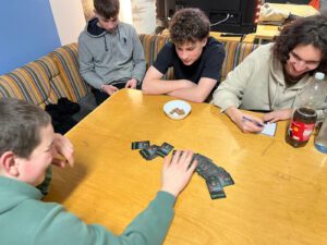 Vier Teenager spielen ein Kartenspiel.