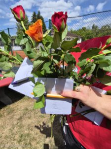 In einer Hand wird ein Blumenstrauß mit Abschlusskarten gehalten.